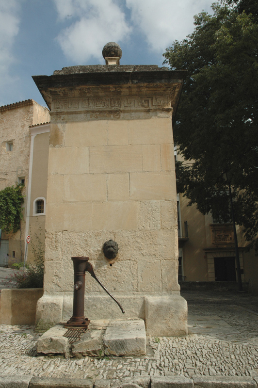 Fontaine réservoir. Saint-Saturnin-les-Apt (Vaucluse). La fontaine, dont il reste le mascaron, à été remplacée par une pompe à bras.