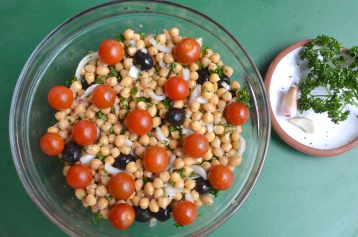 Salade pois chiches, oignons blancs, olives noires et tomates cerises.