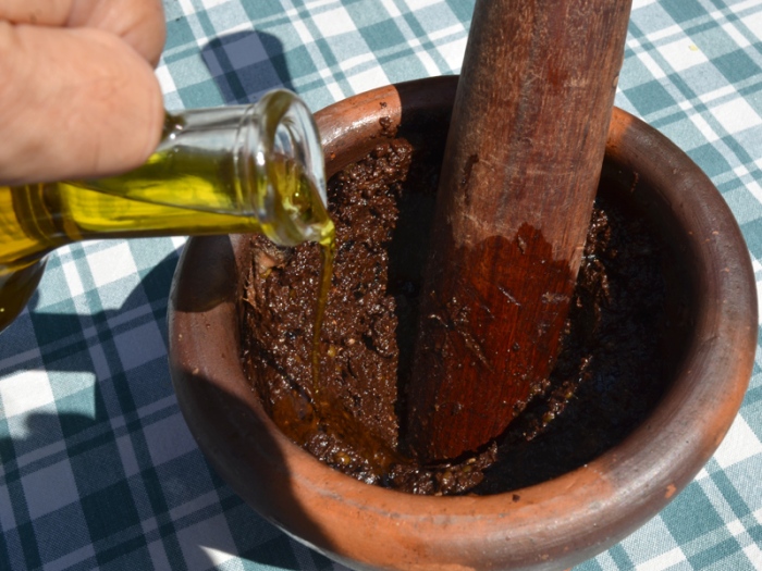 Tapenade provençale d'olives noires. Préparation traditionnelle au pilon dans un mortier. © Serge Panarotto.